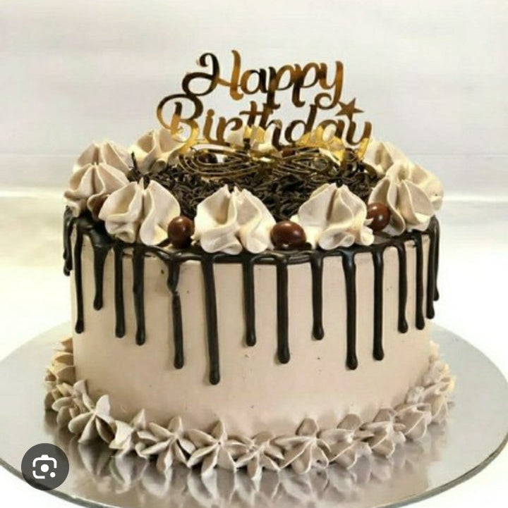 Birthday cake with chocolate drizzle and 'Happy Birthday' topper